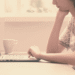 Mujer emprendedora trabajando sola laptop expresión pensativa vulnerable tengo miedo lanzar blog síndrome impostor empezar imperfecta aunque dé miedo build in public cero a cien documentado