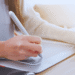 Una mujer escribe con un lápiz digital mientras teclea, diseñando su presencia online.